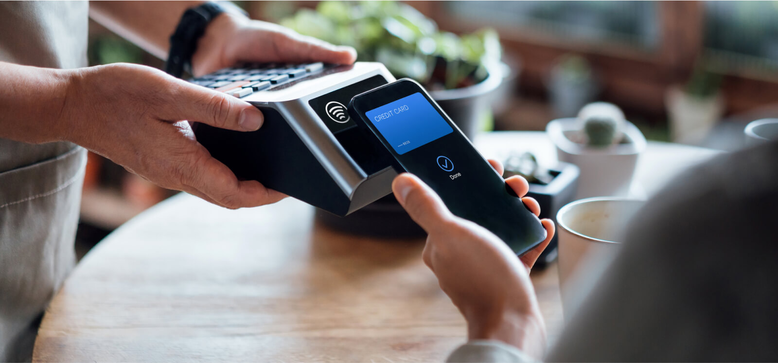 Close-up of a smartphone being held up to a payment processor