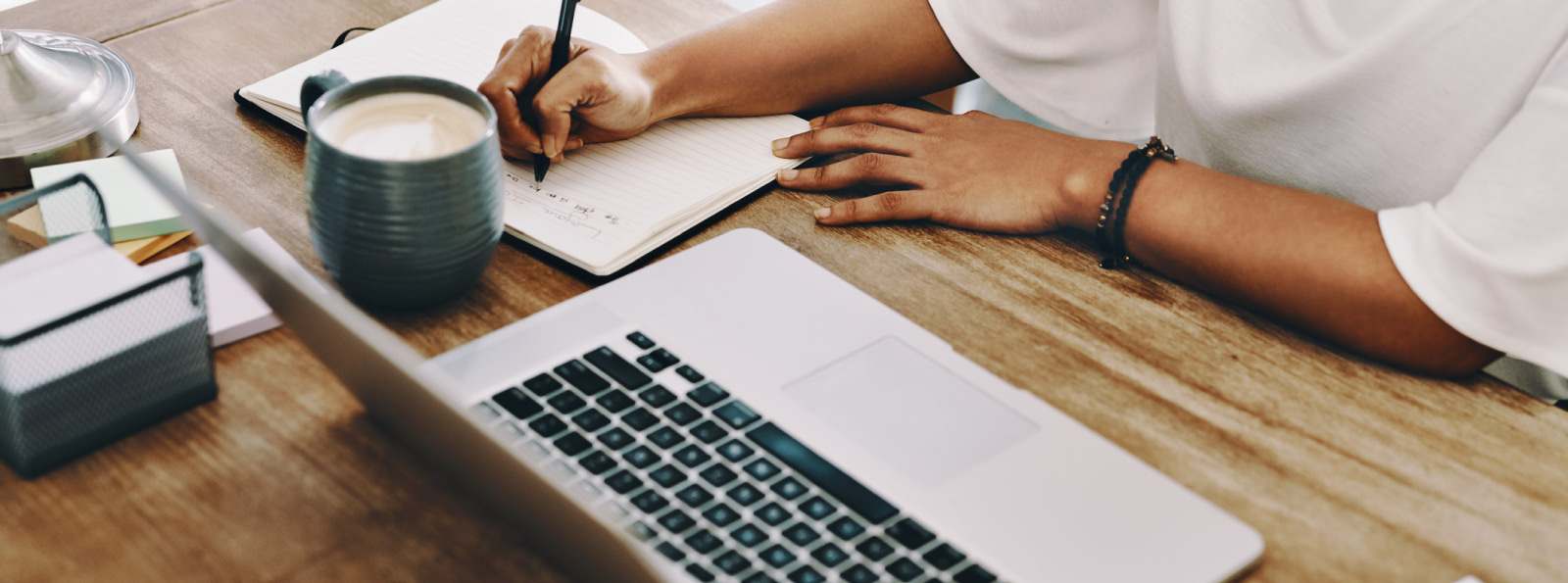 woman taking notes with laptop