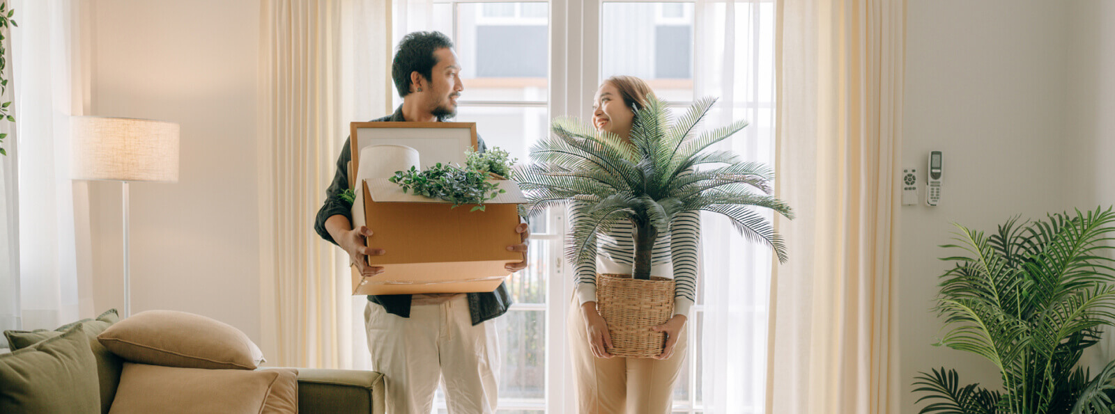 Couple holding moving boxes.                                     